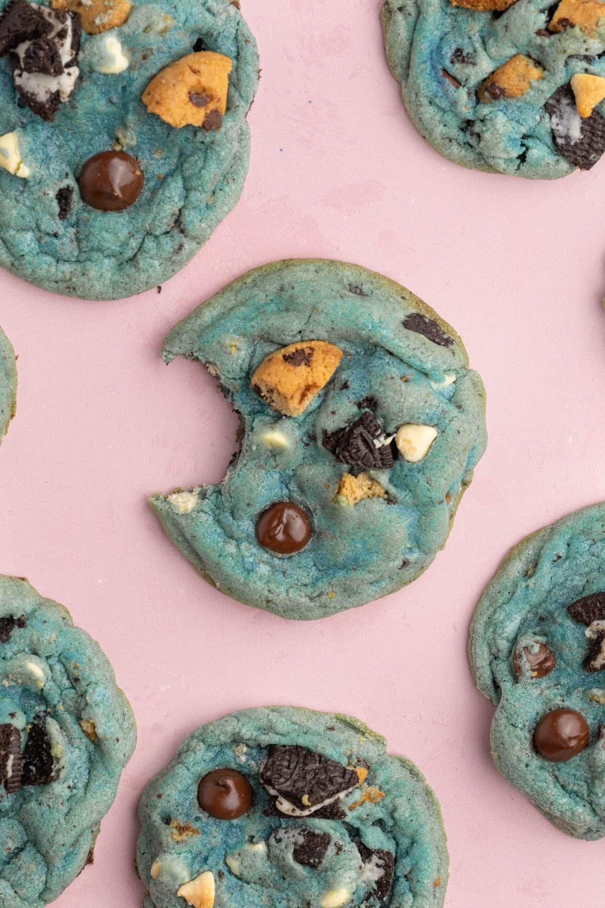 Pink surface with blue cookies, the middle with a bite taken out of it