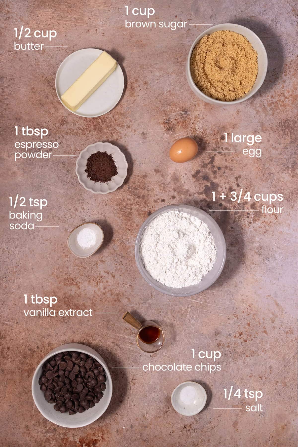 All ingredients needed for Chocolate Chip Coffee Cookies including unsalted butter, light brown sugar, espresso powder, egg, baking soda, all-purpose flour, vanilla extract, chocolate chips, and salt