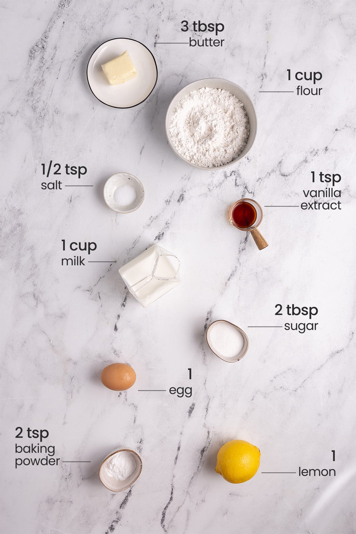 ingredients for lemon pancakes - butter, flour, salt, vanilla extract, milk, sugar, egg, baking powder, lemon