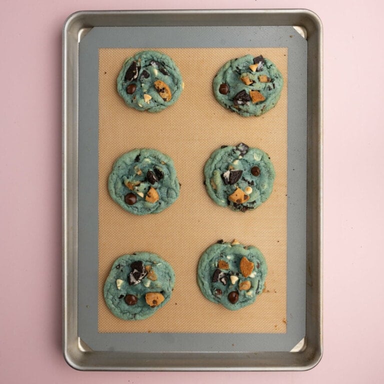 Blue cookie monster cookies fresh out of the oven cooling on the baking sheet