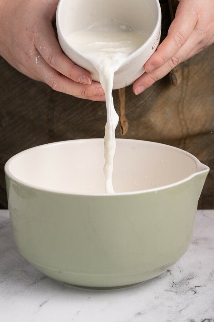 Adding acidified buttermilk to pancake batter.