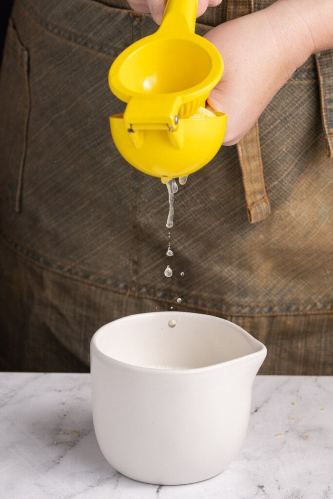 Adding lemon juice to milk to make acidified buttermilk