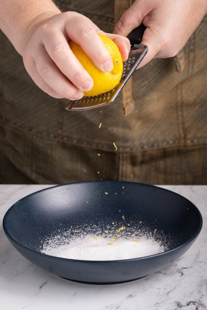 Zesting lemon into a bowl with sugar