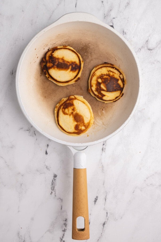 Flipping pancakes in pan to fry on second side