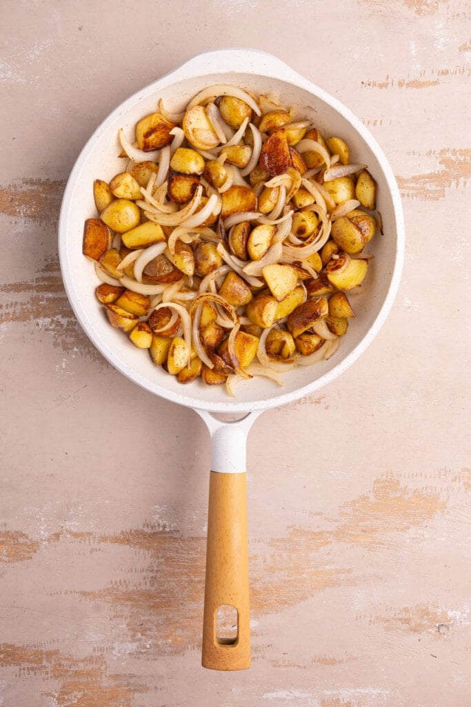 Fully pan-fried potatoes in onions still hot in pan