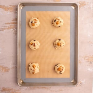 Lined baking sheet with shaped turtle cookie dough