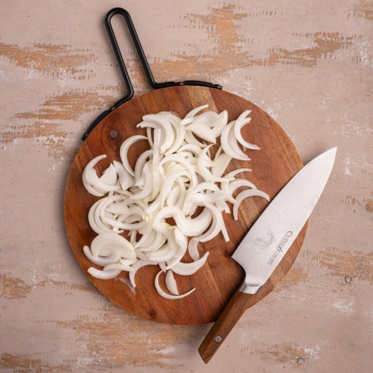 Thinly sliced sweet onion on a chopping board