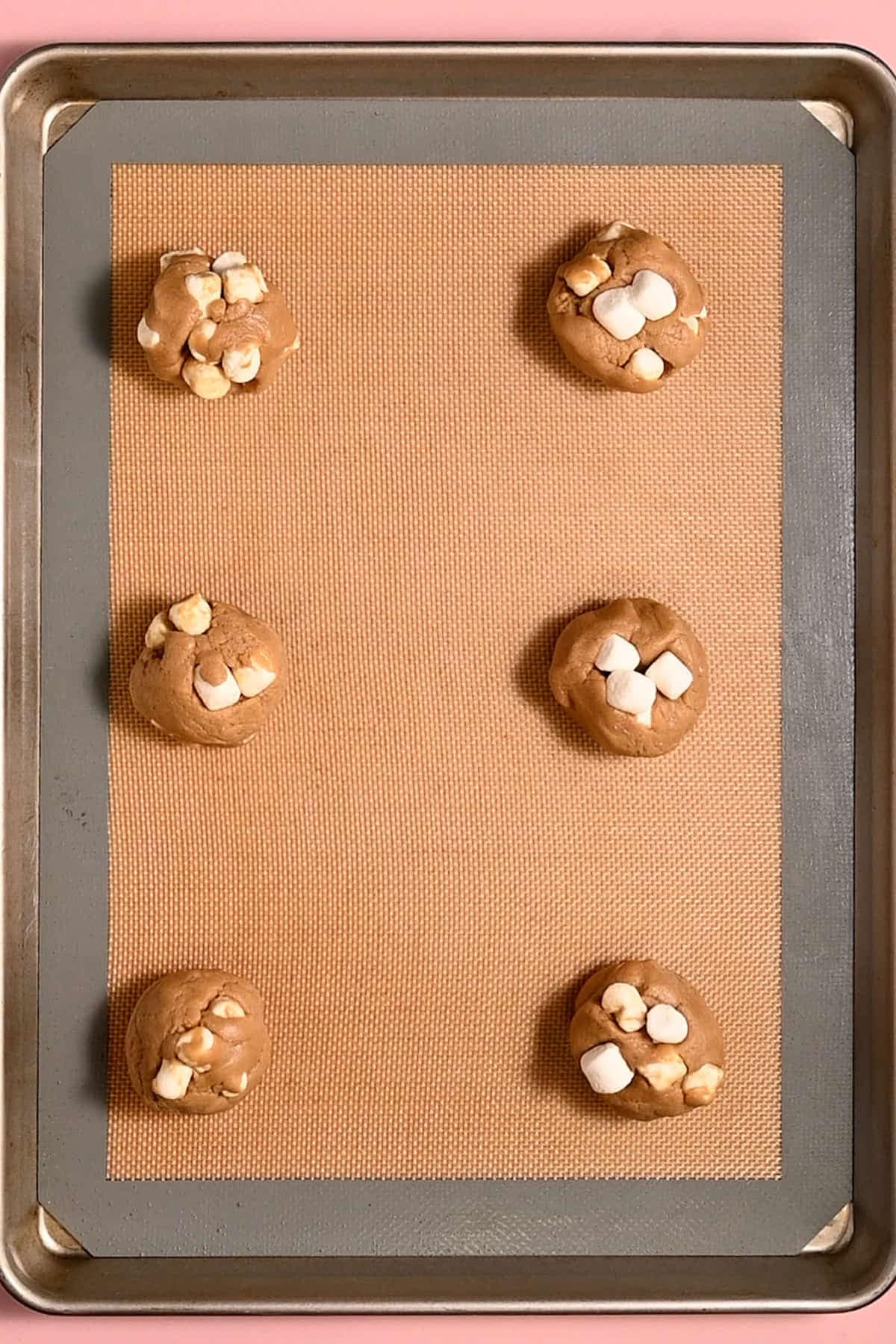 Marshmallow cookies lined up on a baking tray ready for the oven