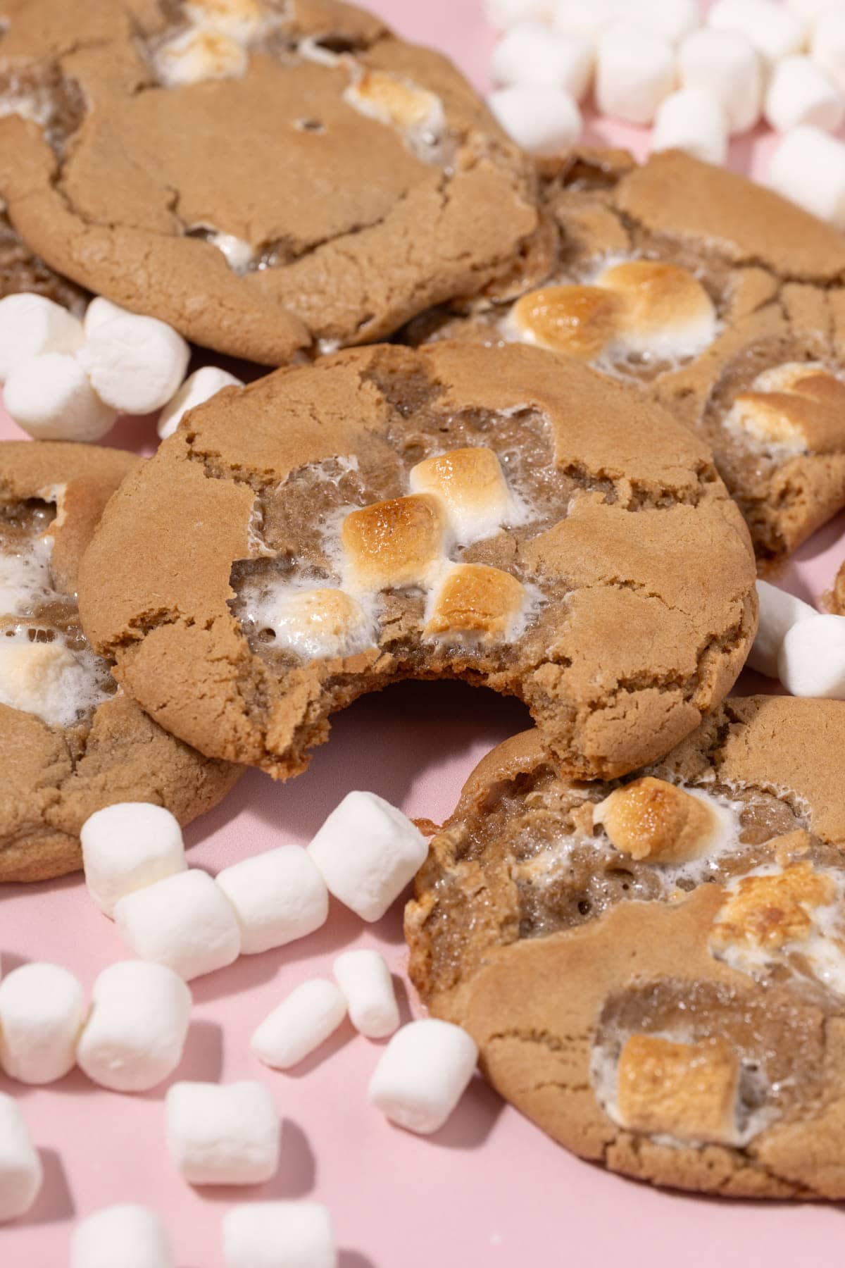 A pile of marshmallow cookies with one having a bite taken out of it