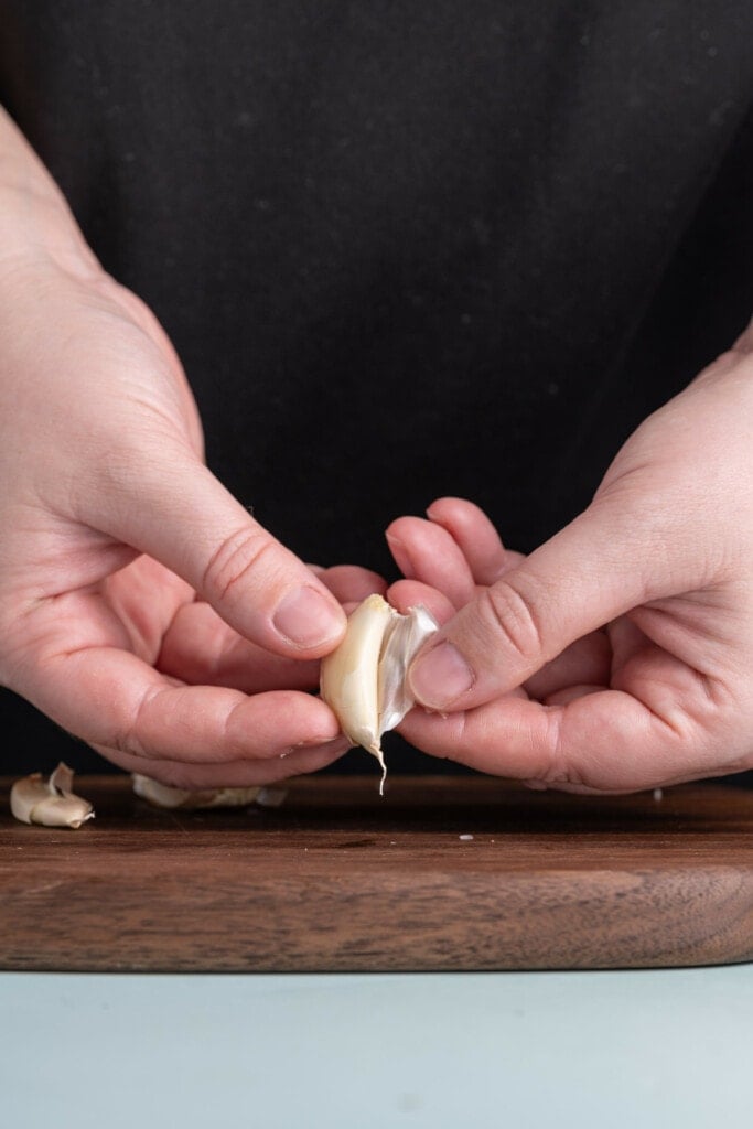 Peeling outermost layer away from garlic