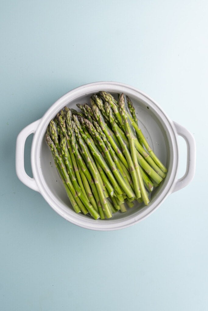 Soaking asparagus in water to thoroughly clean it