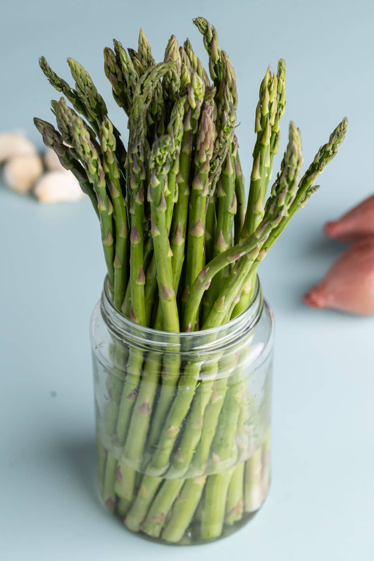 Storing asparagus in a jar with their stems submerged in water to keep it fresh longer