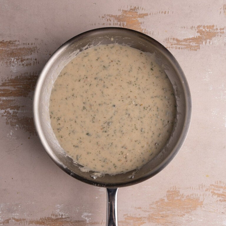 Creamy coconut sage sauce with garlic in a saucepan
