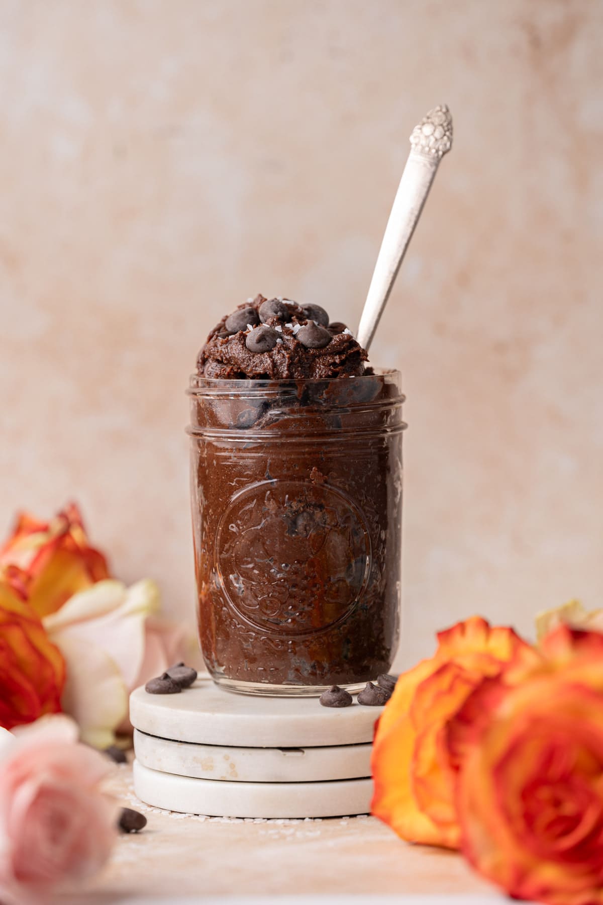 Brownie batter in a jar surrounded by roses