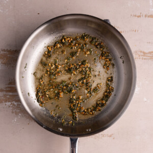 Cooking garlic and sage in coconut oil, salt, pepper, and cumin