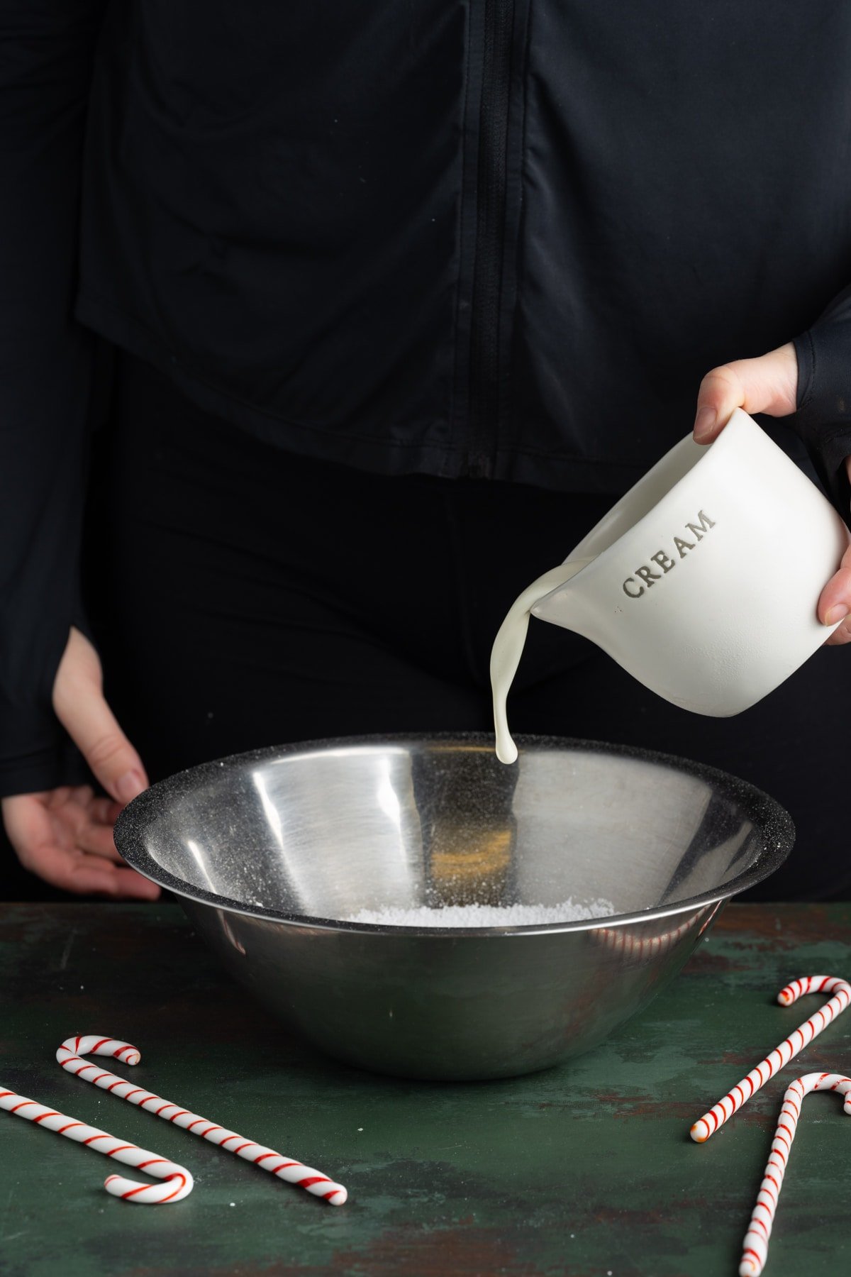 Adding heavy whipping cream to stainless steel bowl