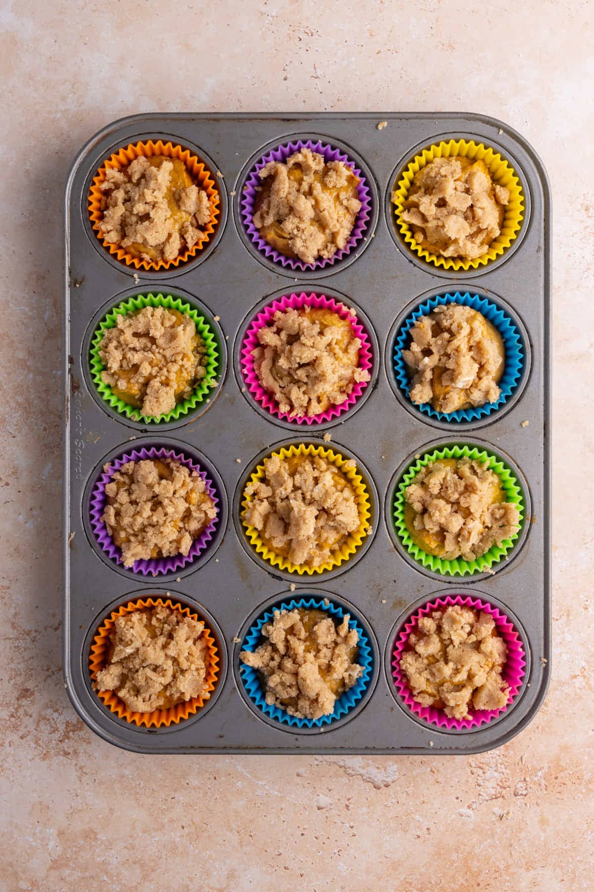 Muffin batter topped with muffin crumble ready for the oven