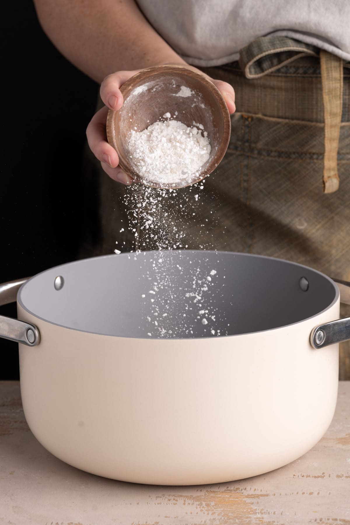 Adding flour to a pot with butter to form a roux