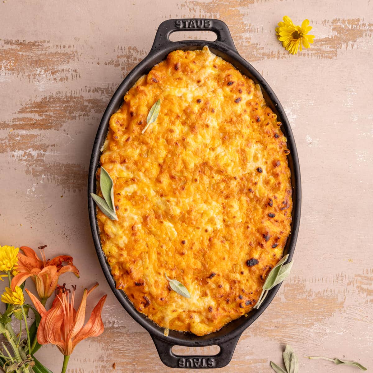 Baked pumpkin mac and cheese garnished with fresh sage