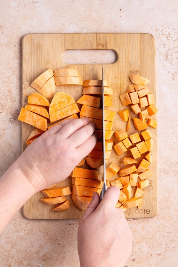 Rotating sliced sweet potatoes to cut into cubes
