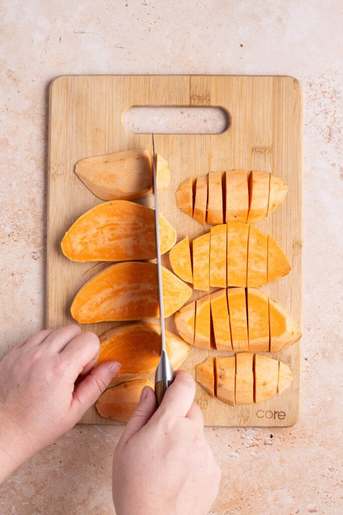Laying sweet potato strips flat to slice