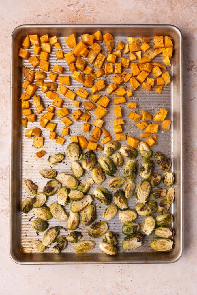Baking tray with freshly roasted sweet potatoes and Brussels sprouts.