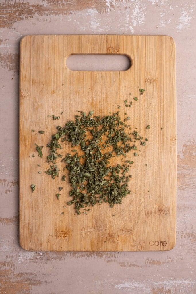 Diced rosemary on a chopping board.