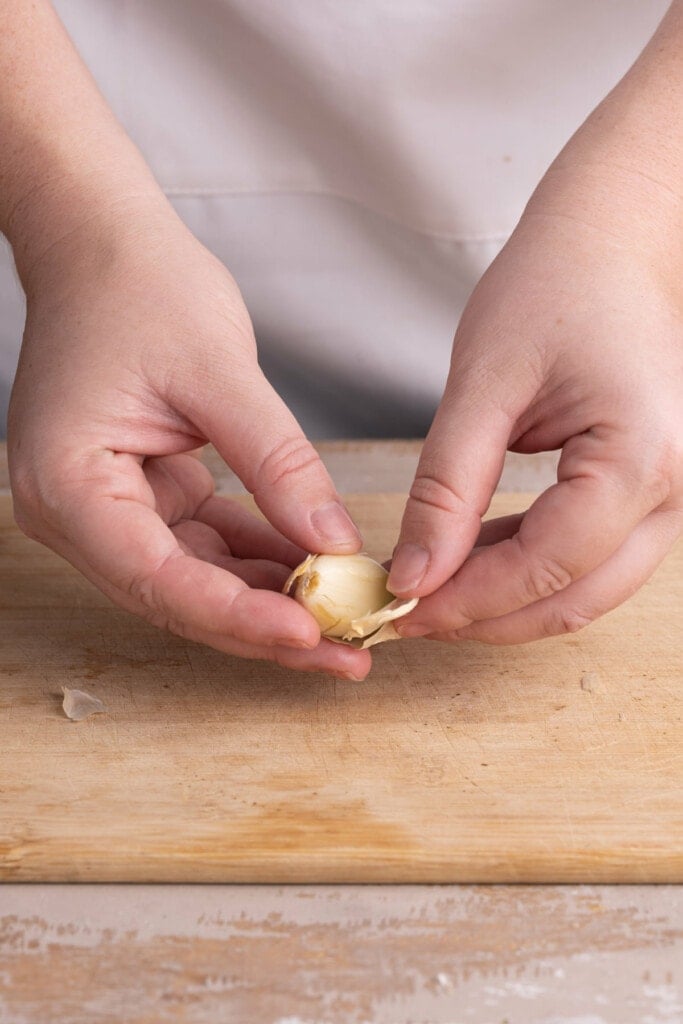 Peeling off the outermost layer of garlic
