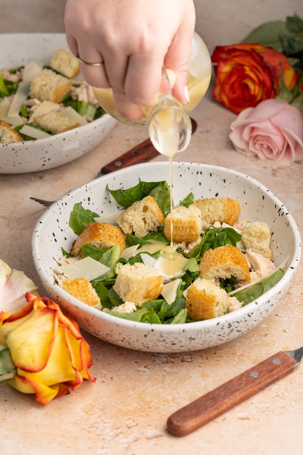 Dressing an individual portion of Caesar salad with homemade dressing
