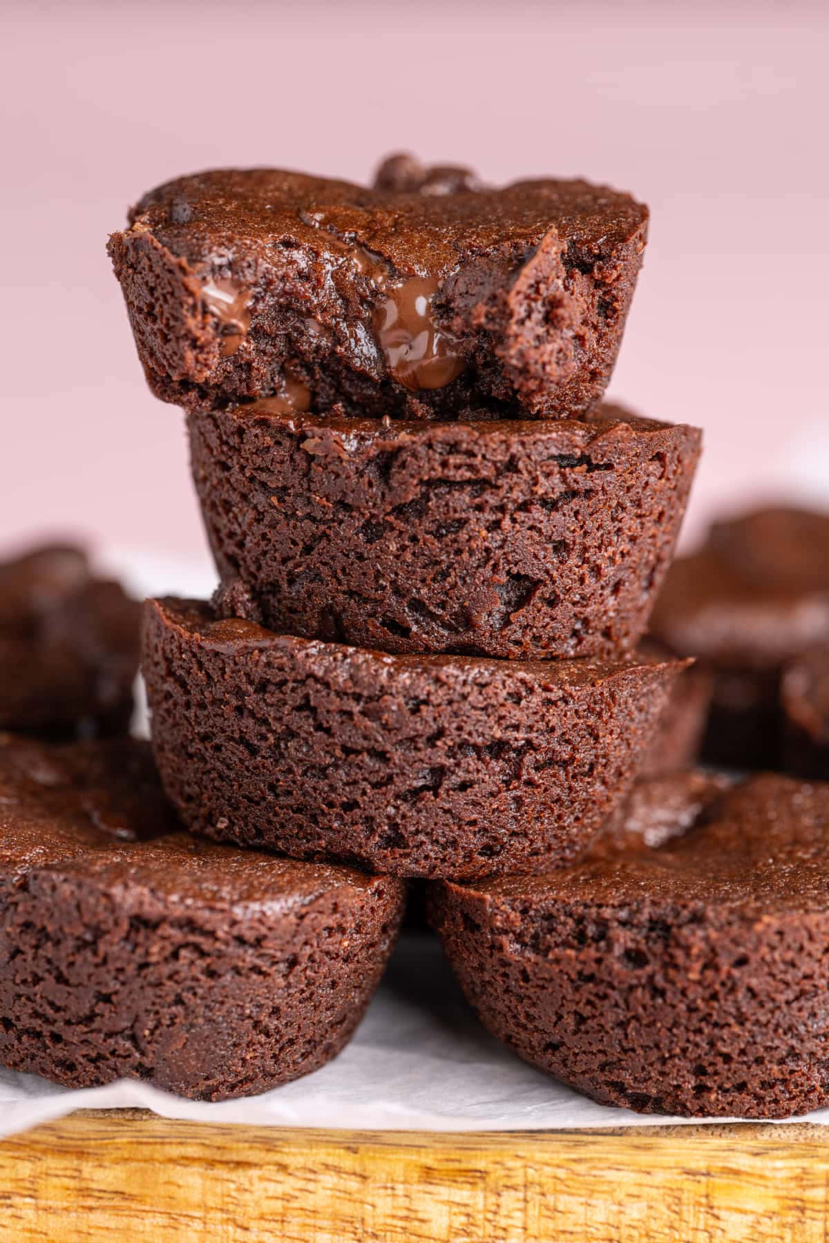A stack of bite-sized brownie rounds with the top one having a bite taken out of it. 