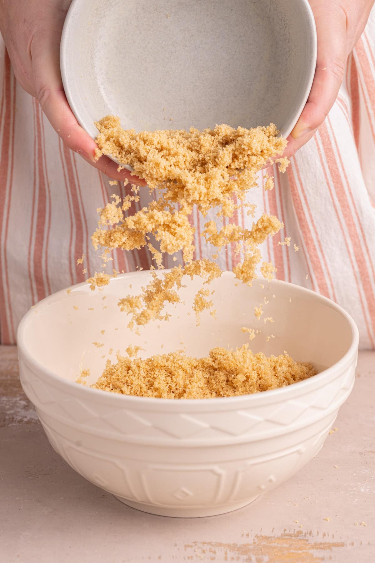 Adding light brown sugar to a bowl with softened unsalted butter.