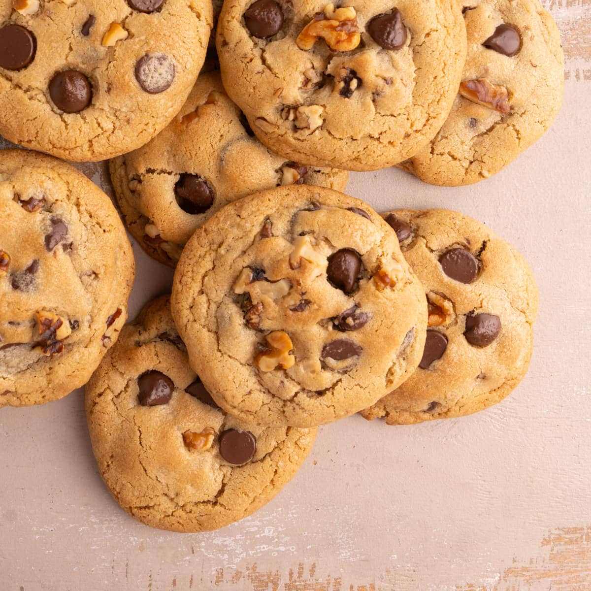 Overhead image of Chocolate Chip Walnut Cookies piled on top of each other with negative space on the lower right corner.