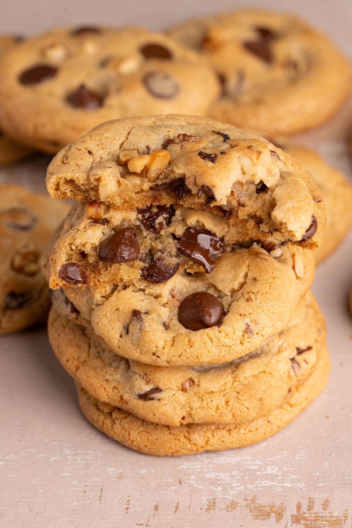 Chocolate Chip Walnut Cookies stacked on top of one another with top one broken in half.