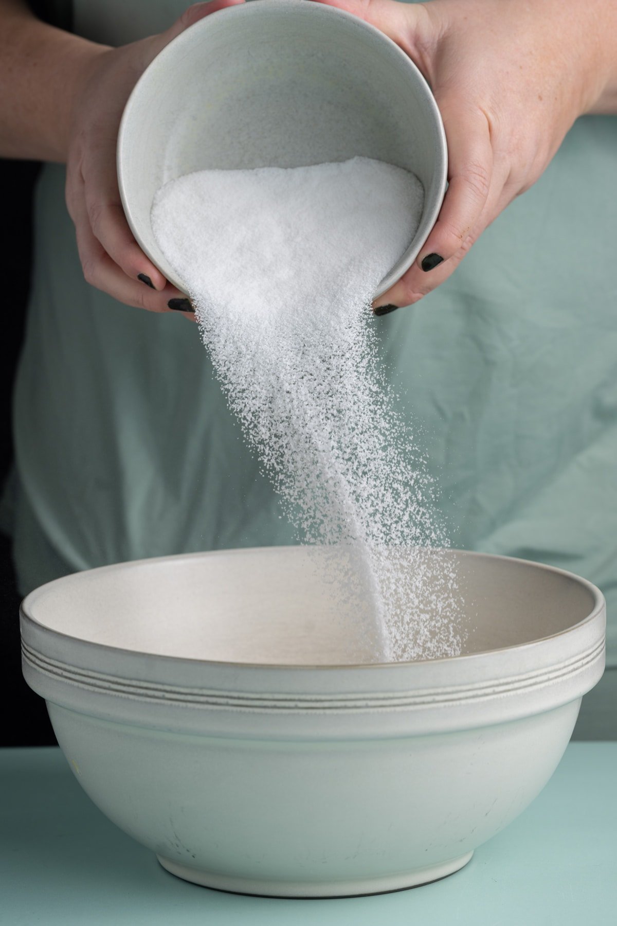 Adding sugar to softened butter to cream together for the base of cookie dough