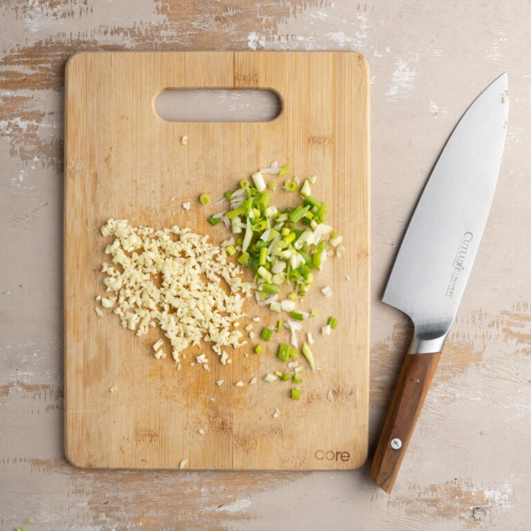 Minced garlic and diced shallots on a cutting board