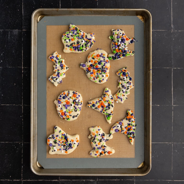 Halloween sugar cookies in a variety of fun and spooky shapes with sprinkles ready for the oven.
