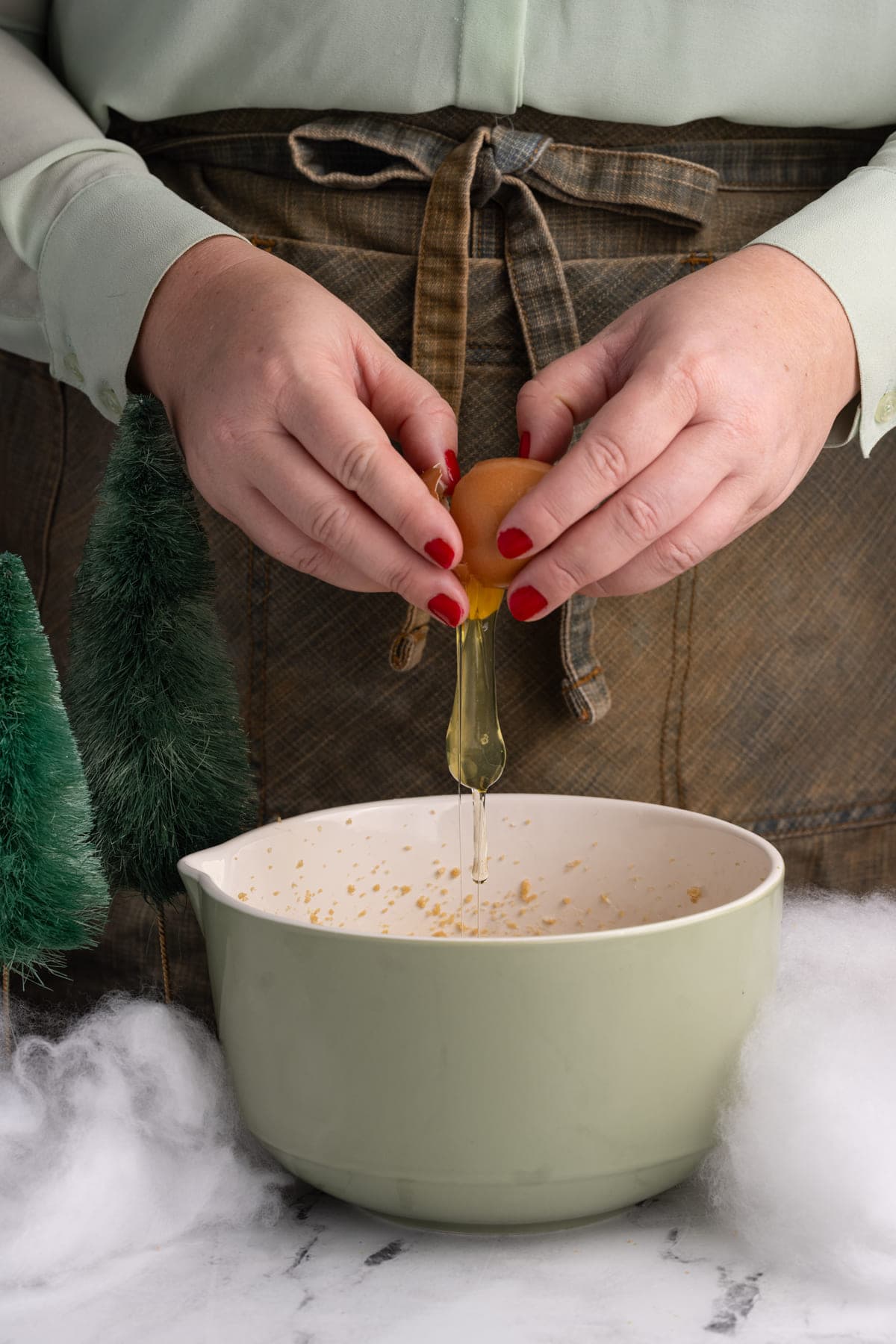 Adding egg to creamed butter and light brown sugar to make cookie dough.