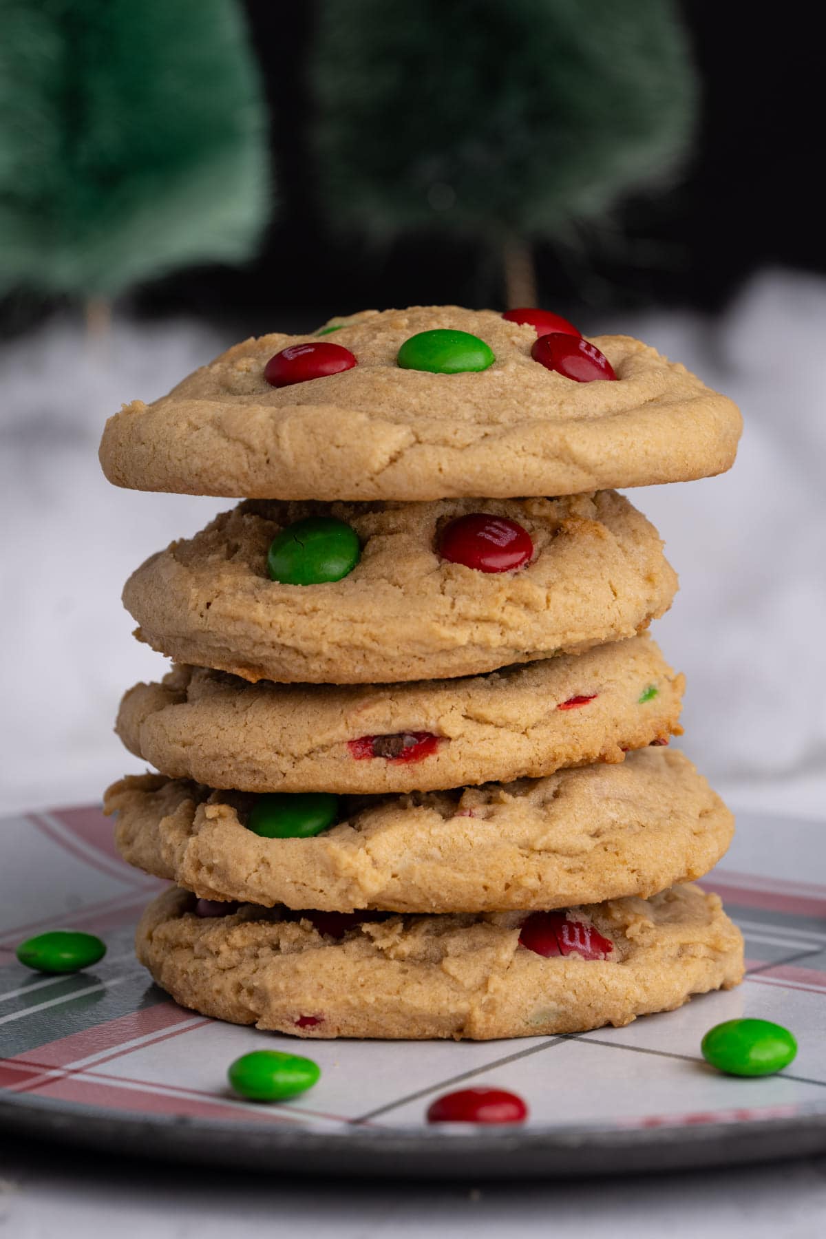 Stack of five Christmas cookies with M&M's stacked on top of each other.