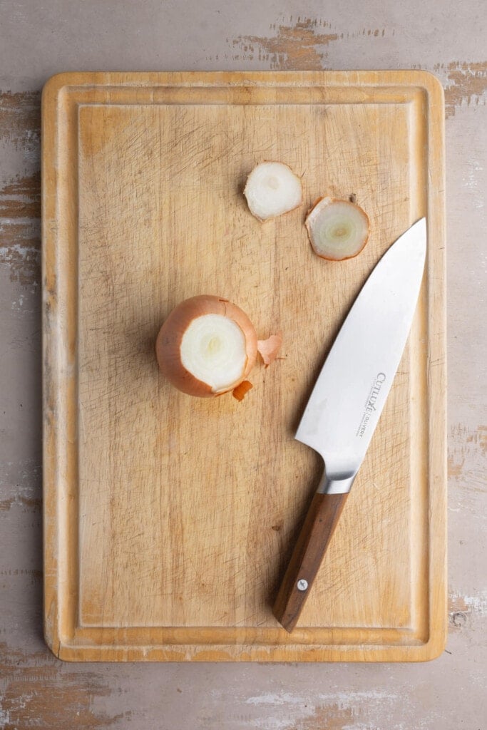 Chopping ends off of an onion.