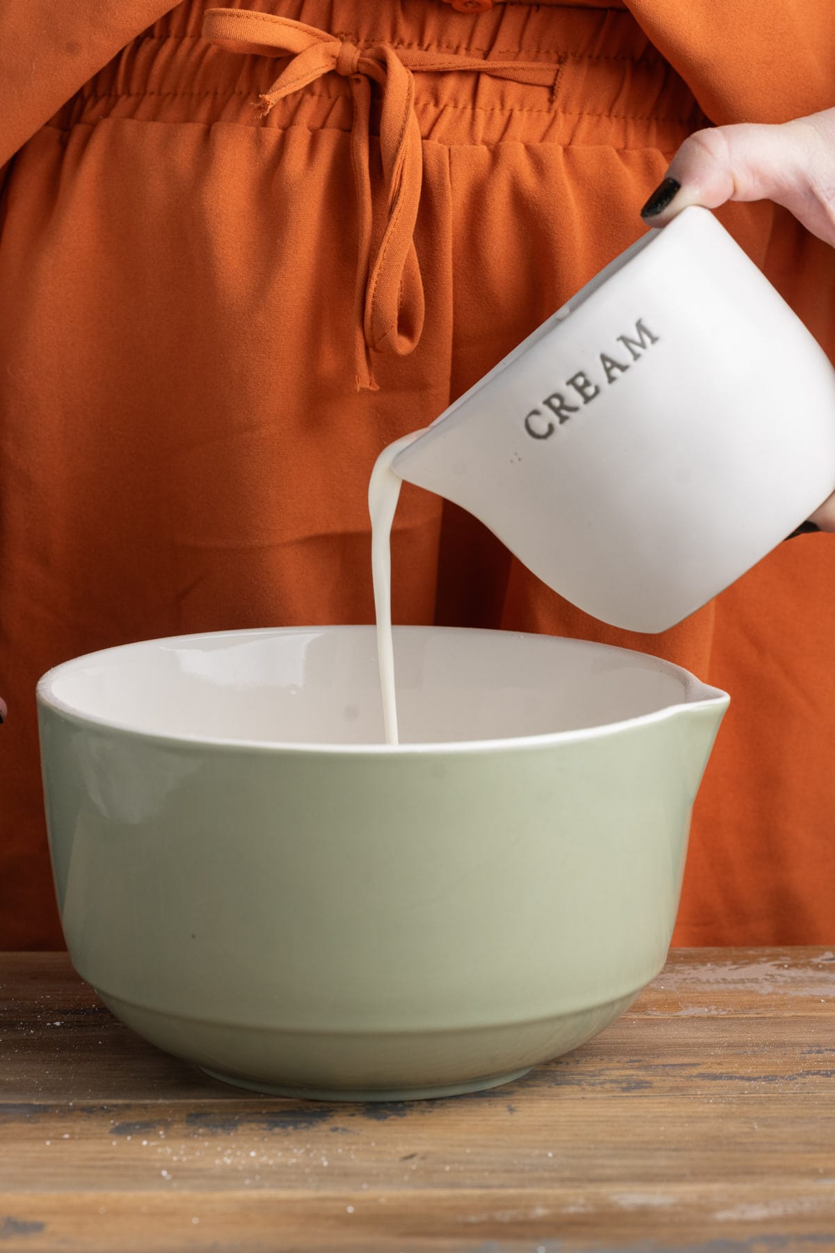 Adding heavy whipping cream to a ceramic bowl
