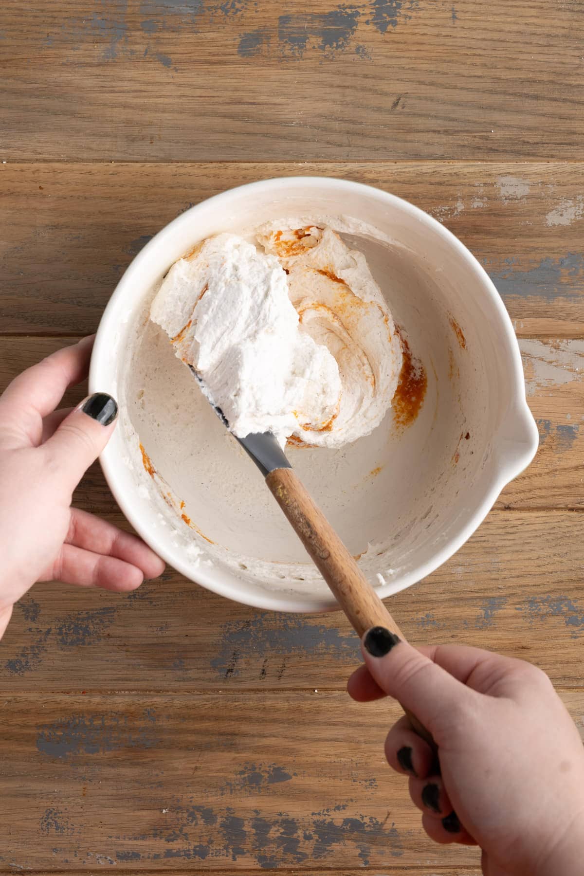 Folding pumpkin puree into homemade whipped cream with pumpkin spice