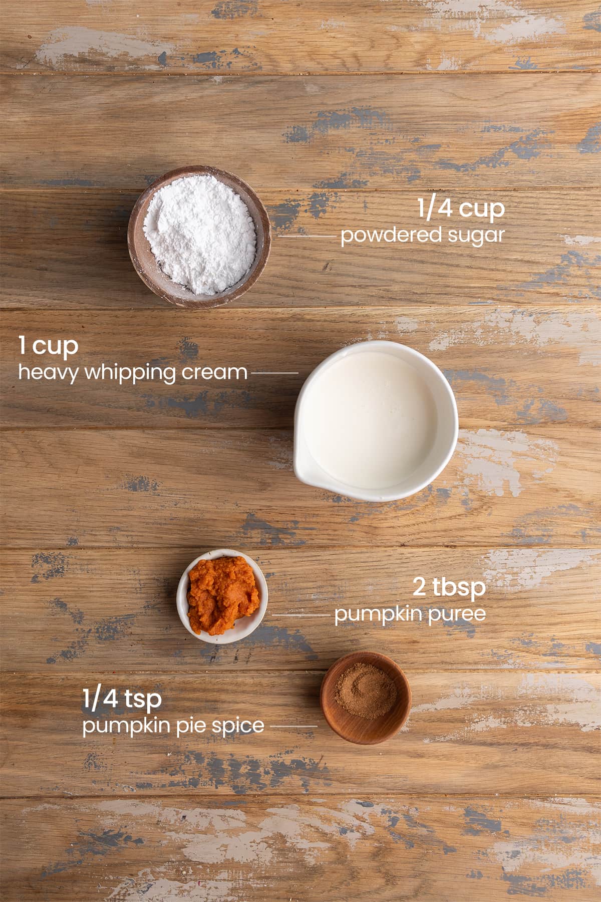 All ingredients needed for Pumpkin Whipped Cream including powdered sugar, heavy whipping cream, pumpkin puree, and pumpkin pie spice