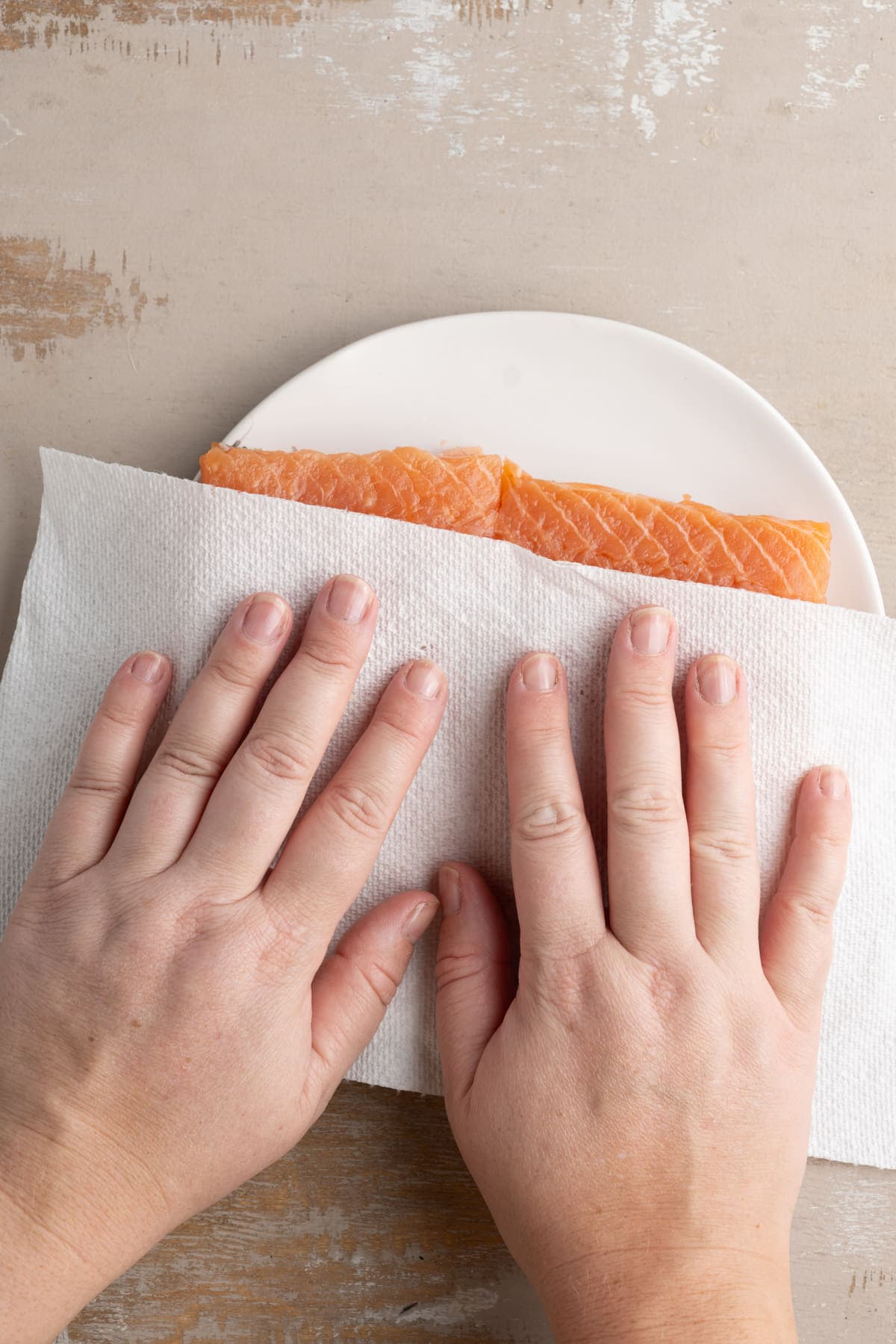 Removing excess moisture from salmon by blotting with paper towels