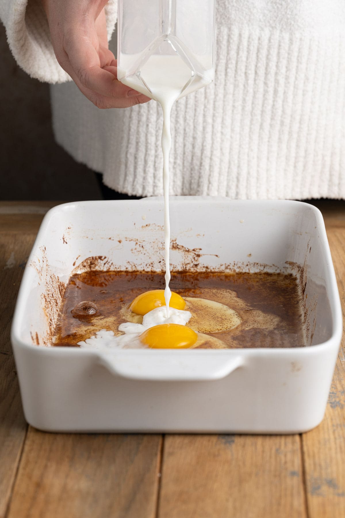 Adding milk to make egg wash for apple cider French toast. 