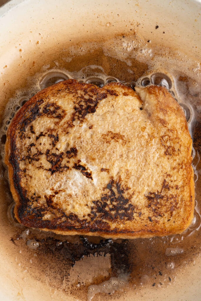 Golden brown French toast frying on the second side.