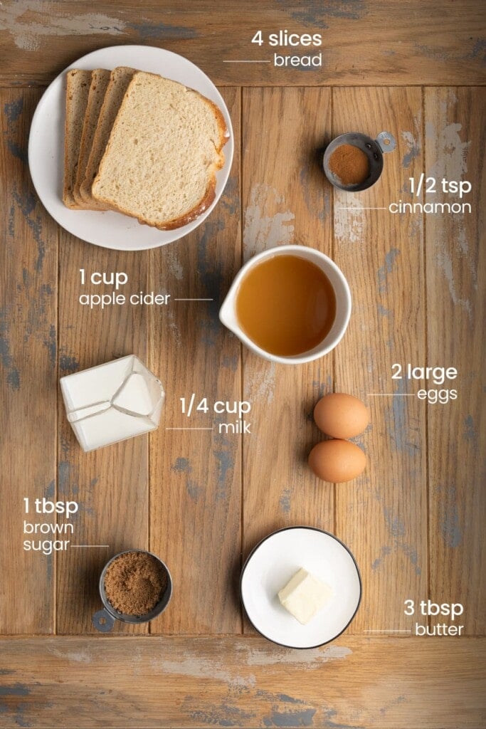 All ingredients you need for Apple Cider French Toast including stale bread, cinnamon, apple cider, milk, eggs, brown sugar, and butter.