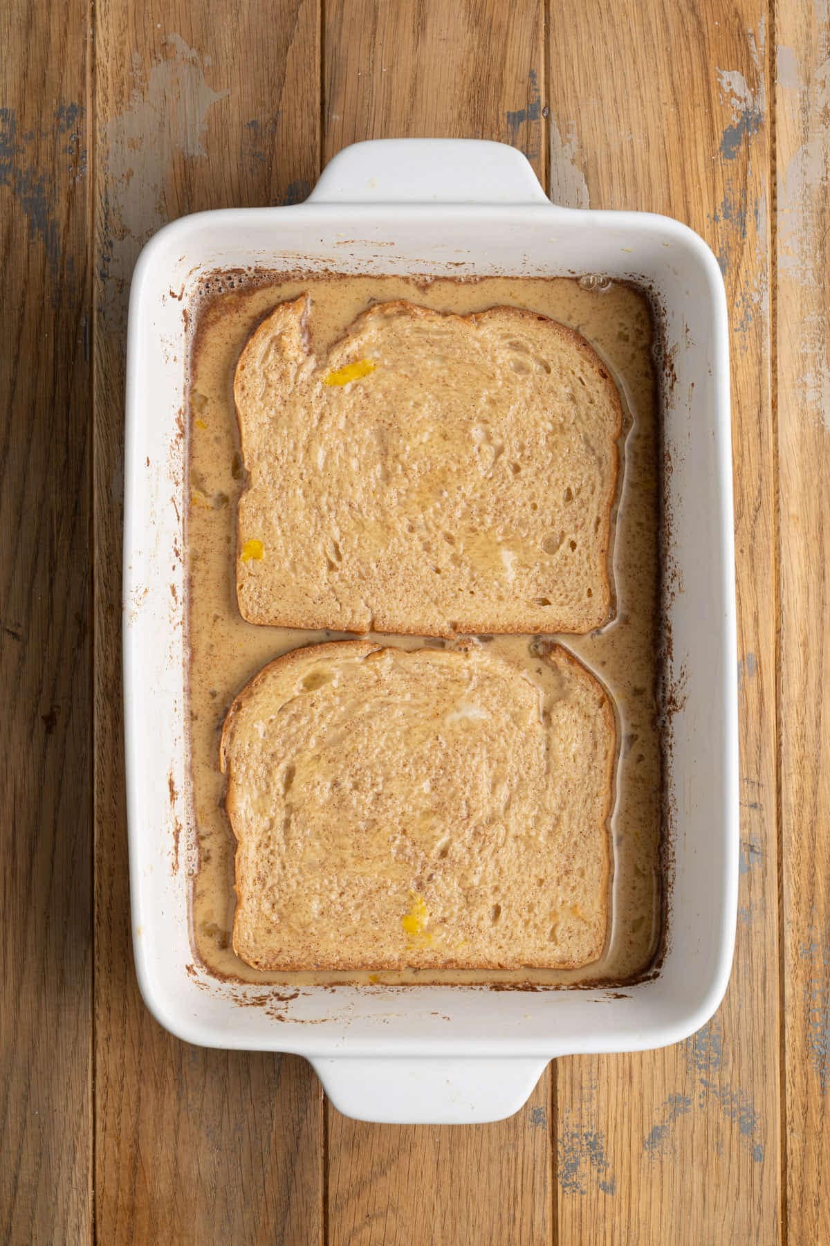 Cider-soaked bread getting coated in egg wash. 