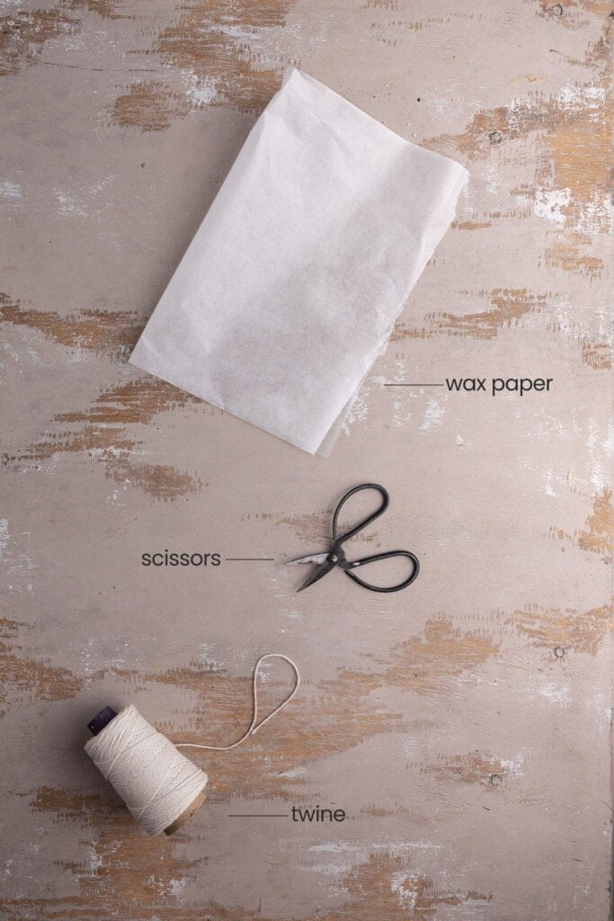All equipment needed to make Cheese Pumpkin including wax paper, twine, and scissors.