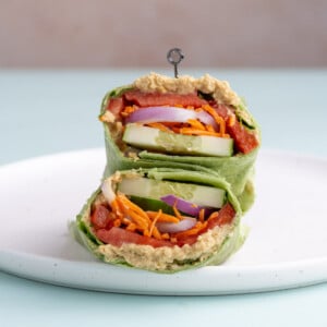 Stacked Vegetable Hummus Wrap on a white plate.