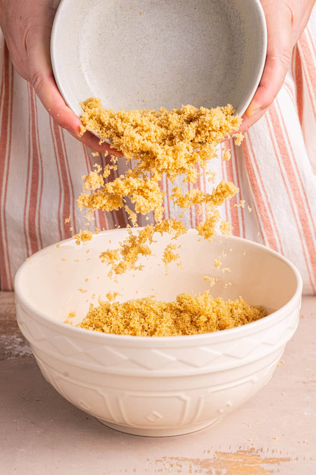 Adding brown sugar to a large mixing bowl to cream with softened butter.